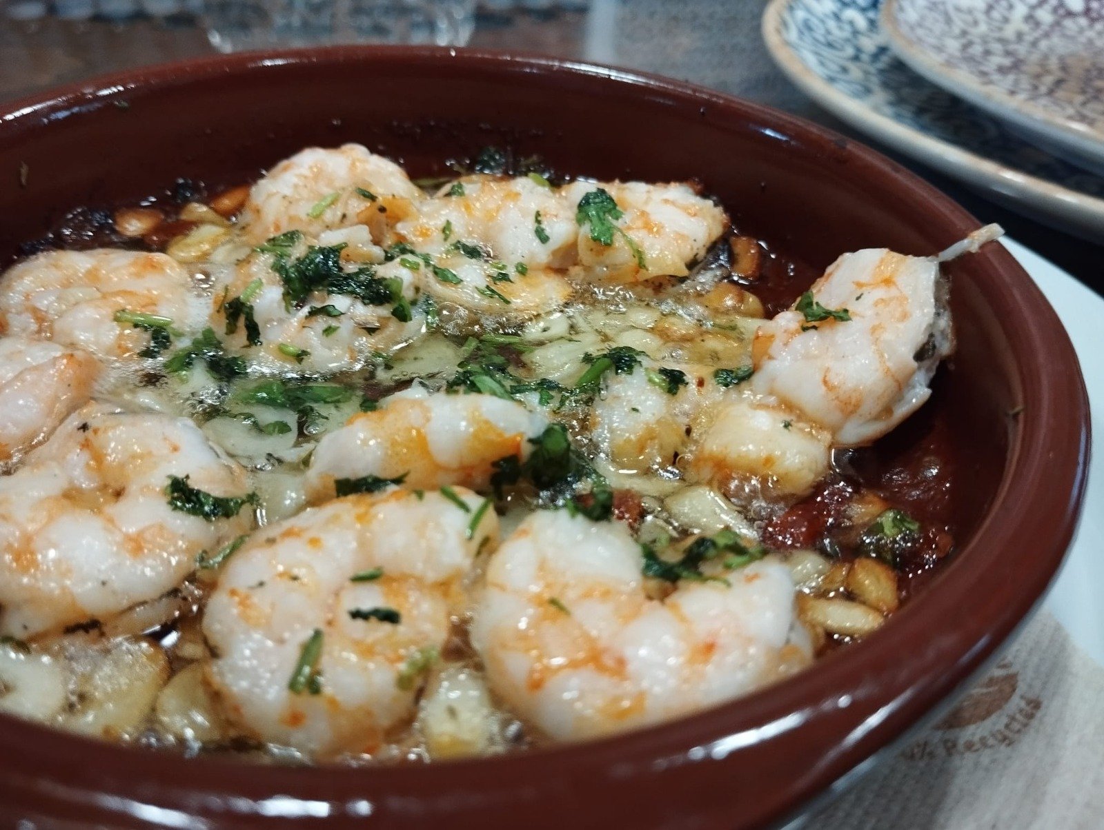 Prawns with garlic and parsley in a clay dish