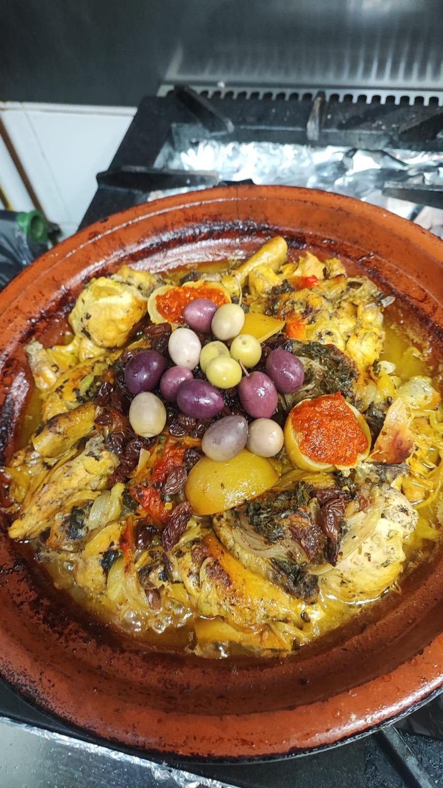 Chicken tajine topped with olives in a clay pot